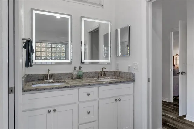 a bathroom with a granite countertop sink and a mirror