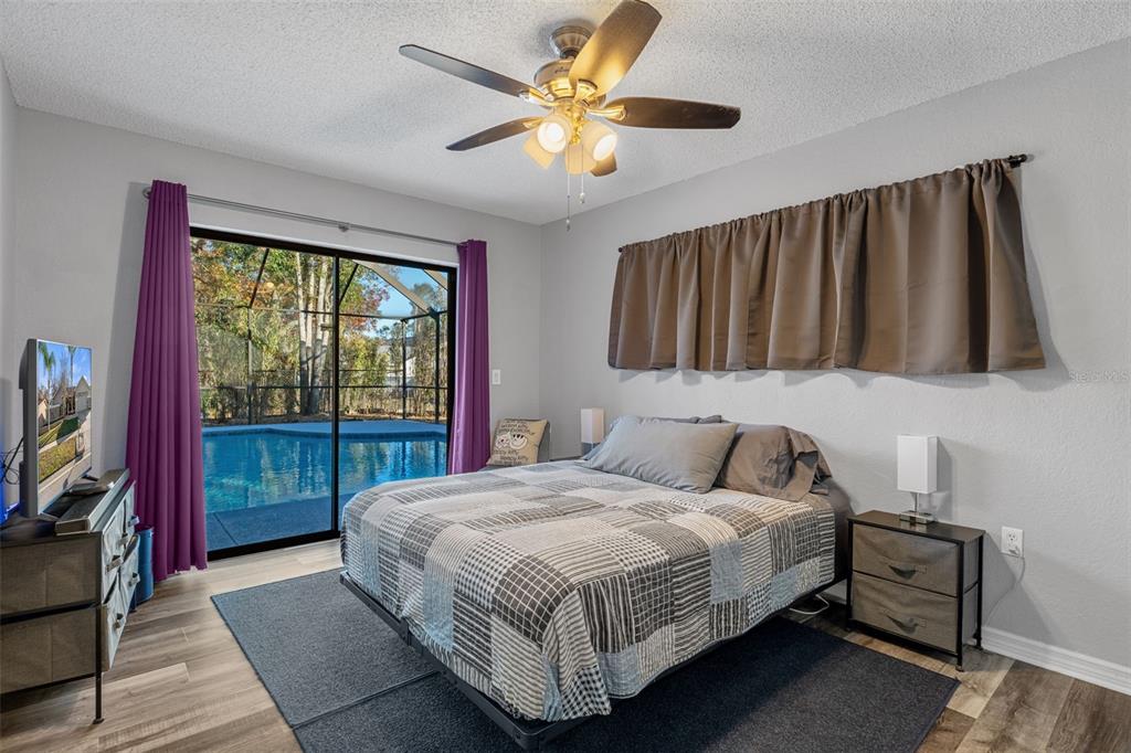 10918 Midland Bridge Road Hudson, FL 34667 - Photo 26 of 42 a bedroom with a bed and a flat tv screen on dresser