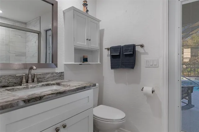 a bathroom with a granite countertop sink toilet and shower