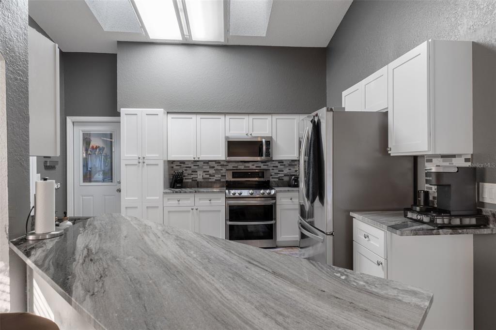 10918 Midland Bridge Road Hudson, FL 34667 - Photo 9 of 42 a kitchen with granite countertop a refrigerator stove and oven
