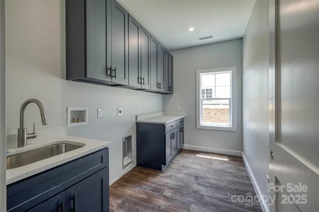 a kitchen with granite countertop white cabinets and stainless steel appliances