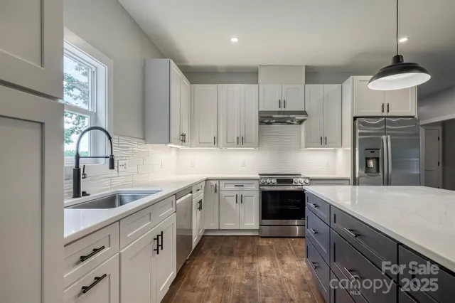 a kitchen with stainless steel appliances granite countertop a sink stove and refrigerator