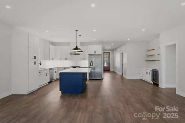 a kitchen with a stove a refrigerator a sink a center island and chairs