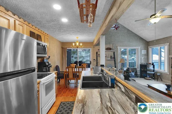 a living room with stainless steel appliances furniture stove and a kitchen view