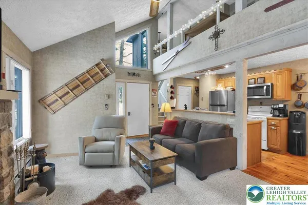 a living room with furniture fireplace and a large window