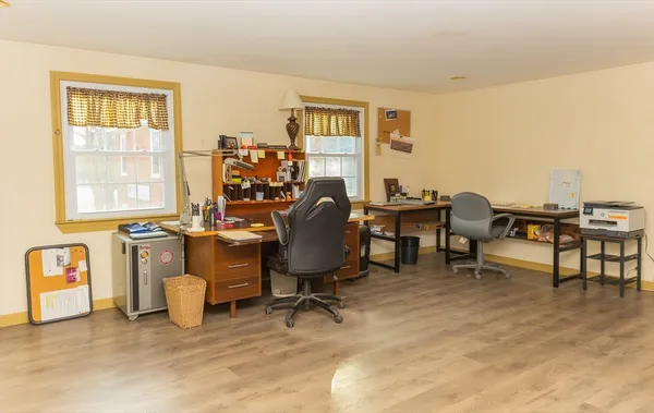 a view of a workspace with furniture and a window