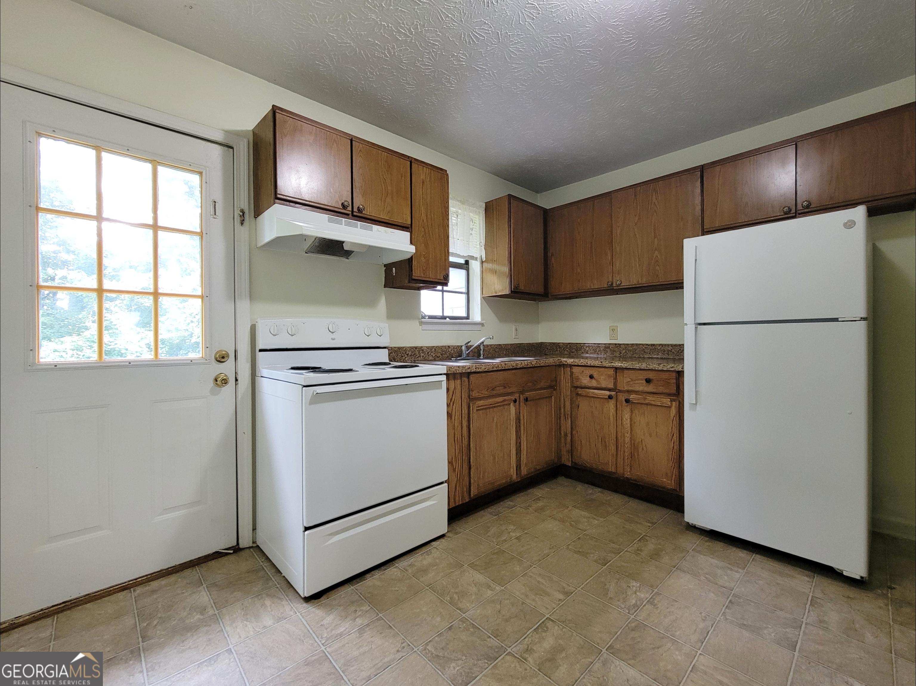 8 Candlewood Terrace Northeast, Unit 2 Winder, GA 30680 - Photo 3 of 8 a kitchen with white cabinets and white appliances