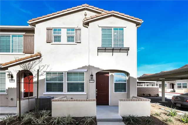 a front view of a house with glass windows and couches