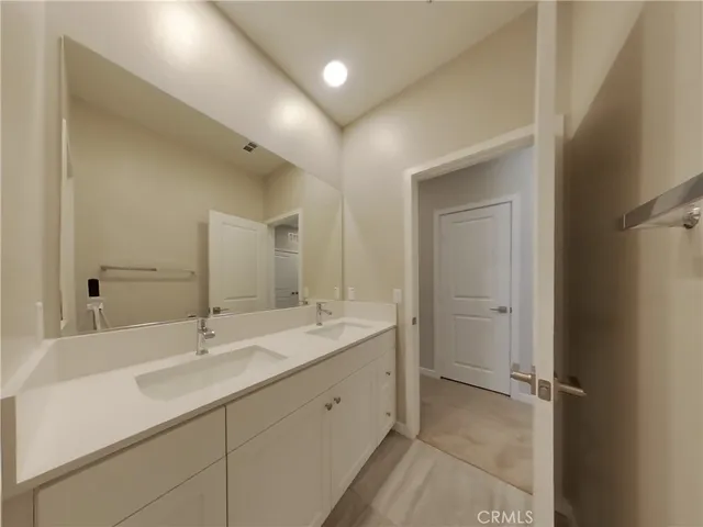 a bathroom with a double vanity sink a mirror and a shower