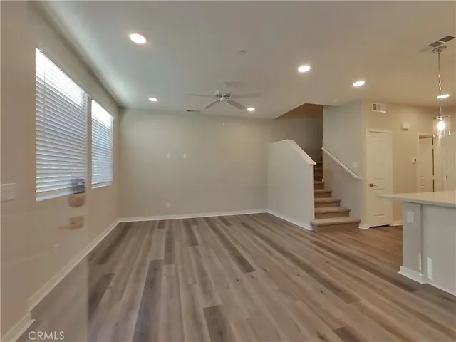 an empty room with wooden floor and staircase