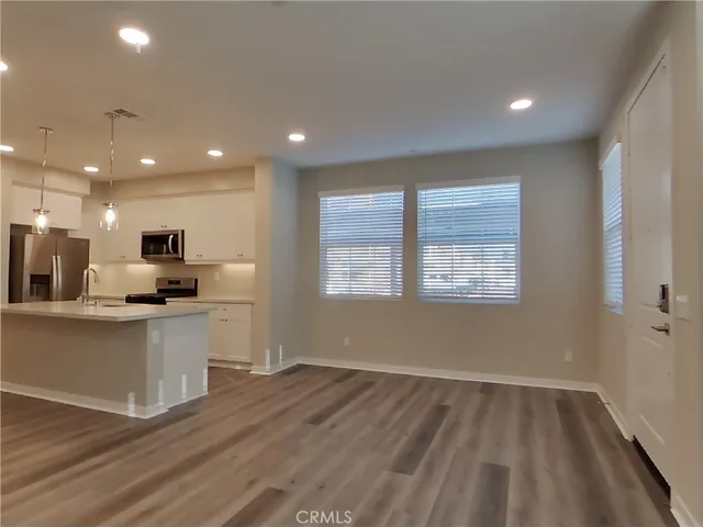 a view of kitchen with wooden floor and electronic appliances