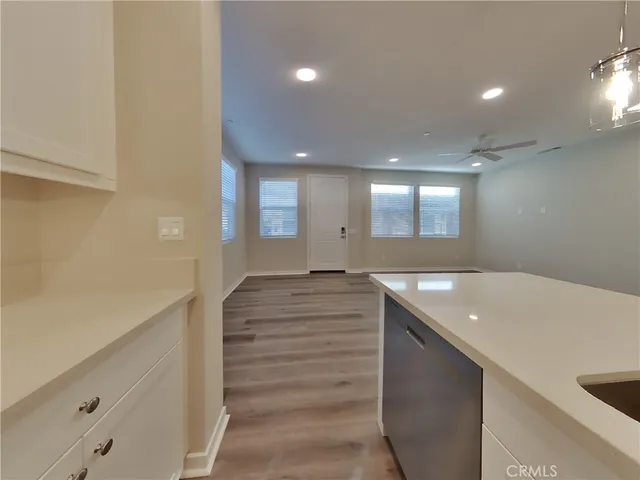 a kitchen with a sink and dishwasher with wooden floor