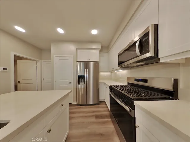 a kitchen with stainless steel appliances a stove a microwave and a refrigerator