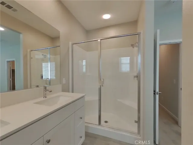a bathroom with a shower sink and mirror