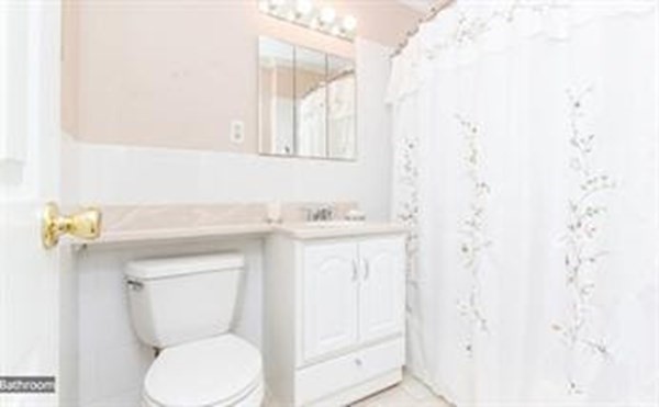 151 Tremont Street, Unit 7B Boston, MA 02111 - Photo 8 of 14 a bathroom with a toilet sink and mirror