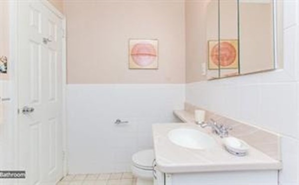 151 Tremont Street, Unit 7B Boston, MA 02111 - Photo 9 of 14 a bathroom with a sink and a mirror