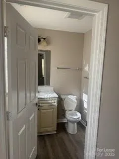 a bathroom with a granite countertop toilet and a sink