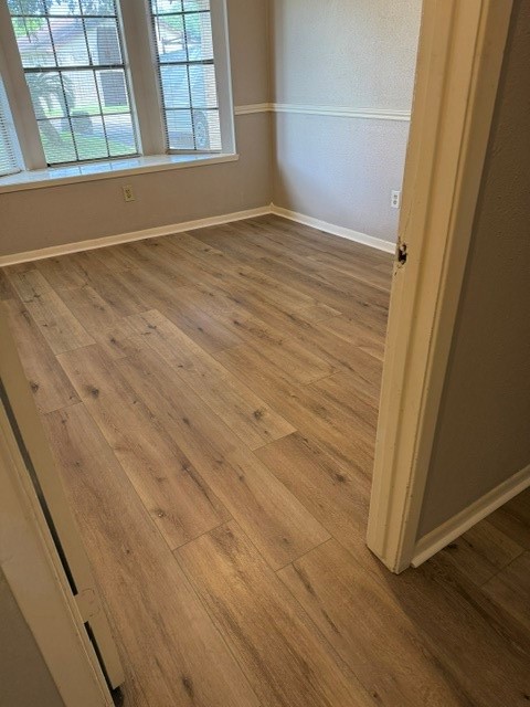5102 Parsley Avenue Baytown, TX 77521 - Photo 14 of 19 an empty room with wooden floor and windows