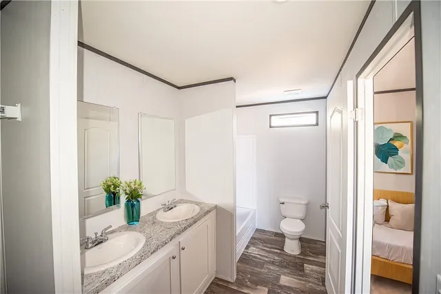 a bathroom with a granite countertop sink a toilet and shower
