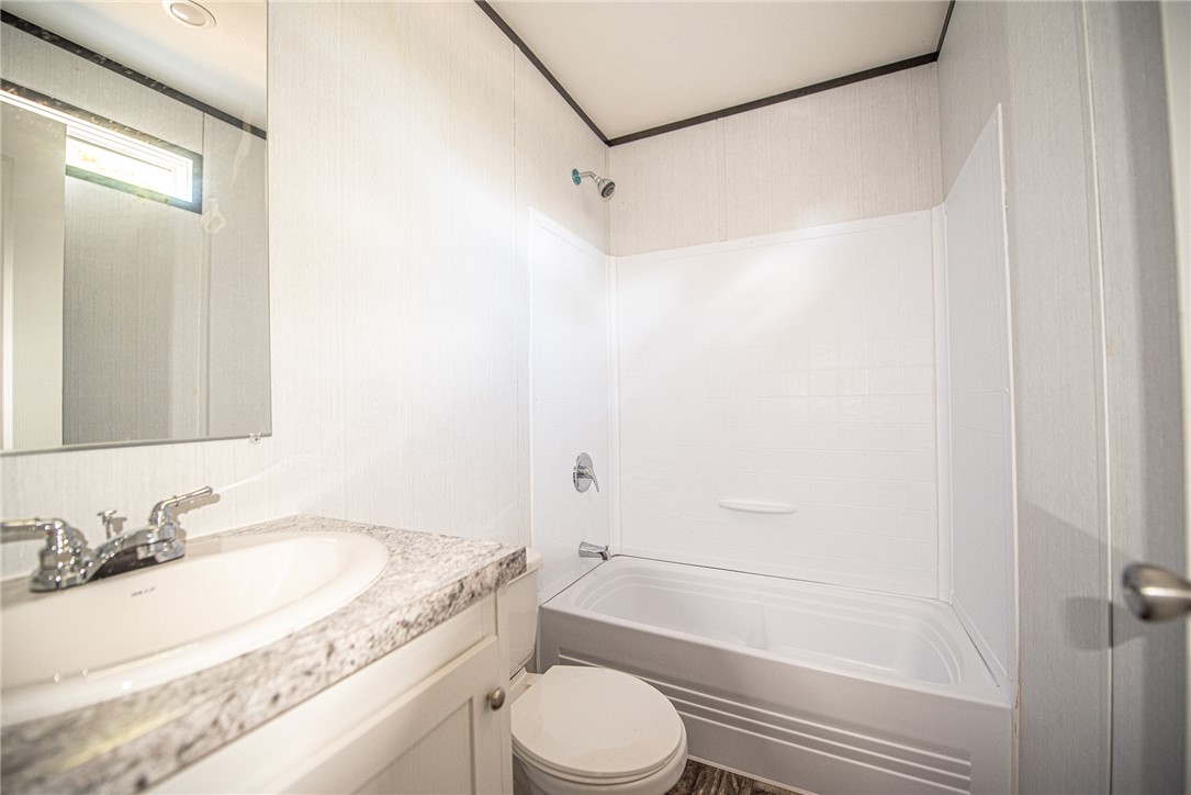 551 Boysenberry Road Somerville, TX 77879 - Photo 17 of 38 a bathroom with a granite countertop sink toilet and shower
