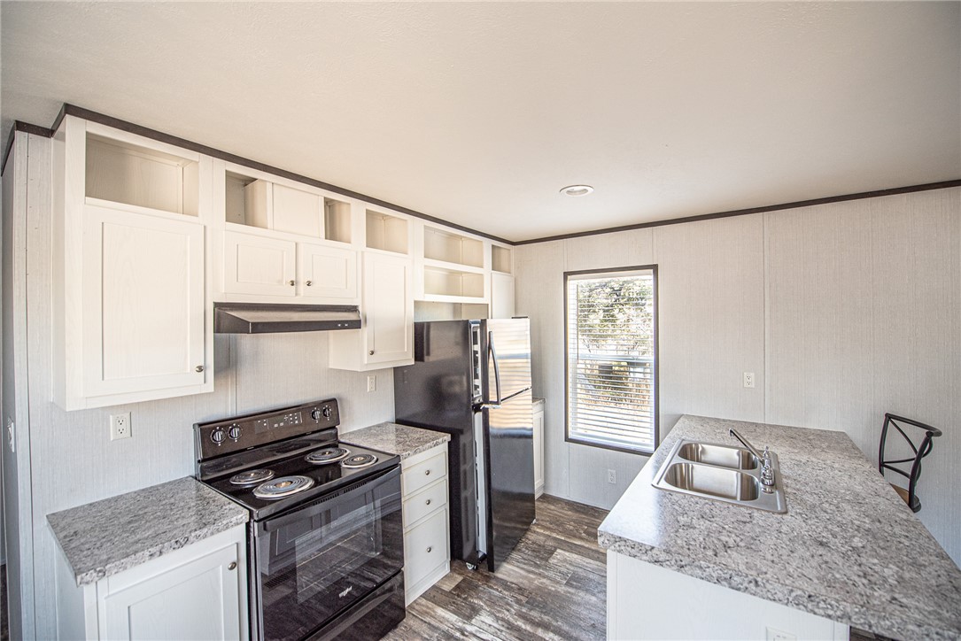 551 Boysenberry Road Somerville, TX 77879 - Photo 7 of 38 a kitchen with granite countertop a sink stove and refrigerator