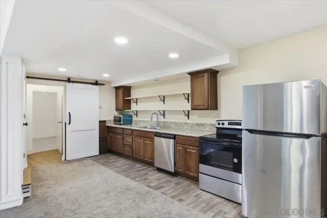 a large kitchen with stainless steel appliances granite countertop a lot of counter space and a sink