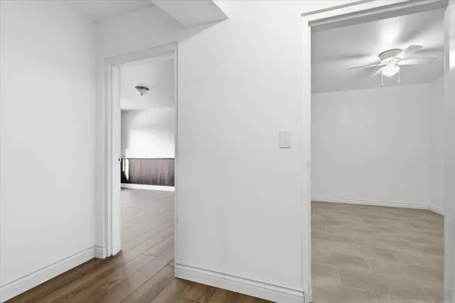 an empty room with a ceiling fan and entryway