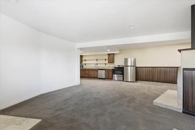a large kitchen with stainless steel appliances granite countertop a sink and a refrigerator