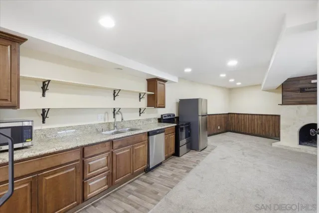a kitchen with granite countertop stainless steel appliances and refrigerator