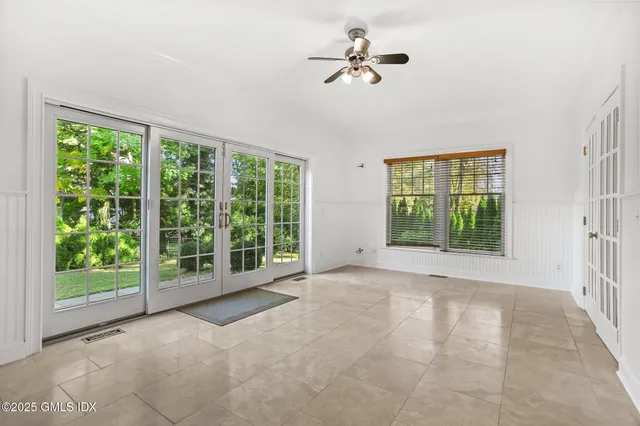 an empty room with wooden floor and window