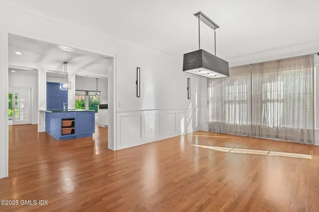 a view of a room with wooden floor a ceiling fan and windows