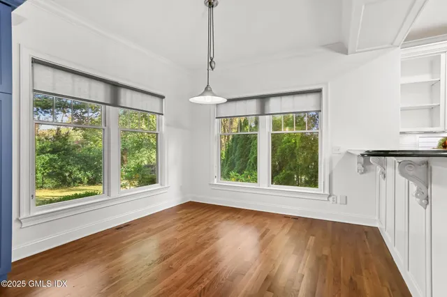 a view of an empty room with a fireplace and a window
