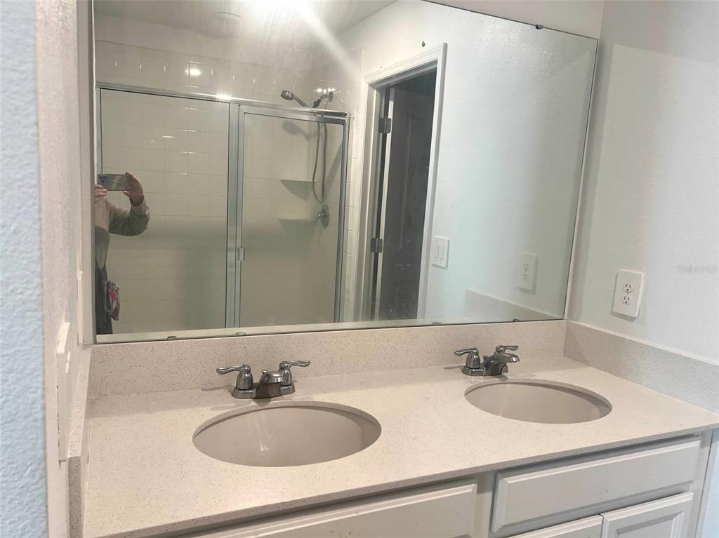 5554 Braken Fern Way Leesburg, FL 34748 - Photo 13 of 16 a bathroom with a sink and a mirror