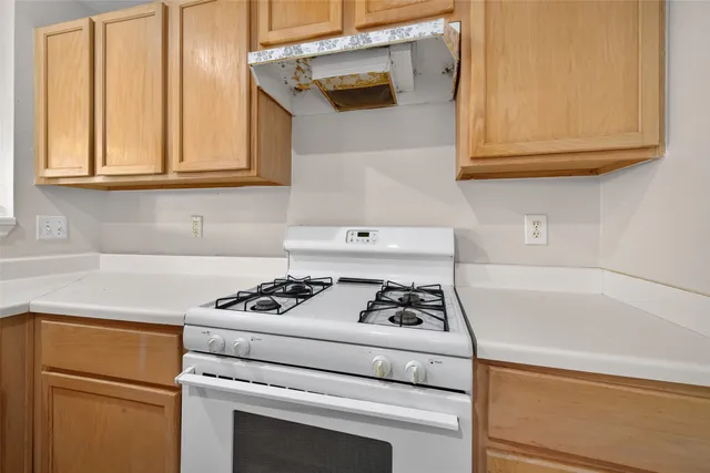 a white stove top oven sitting inside of a kitchen