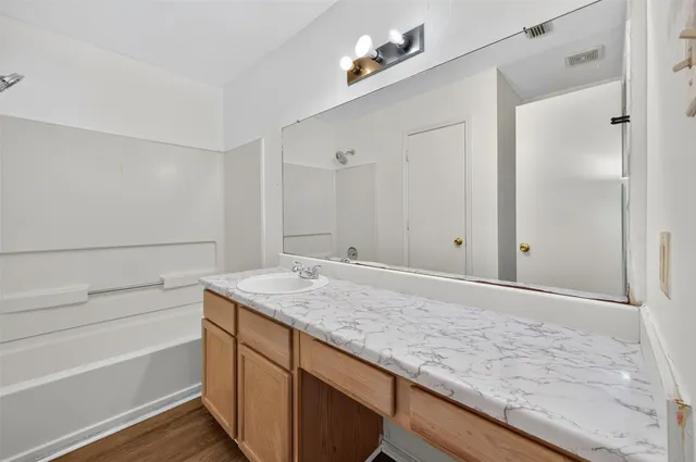 a bathroom with a granite countertop sink and mirror