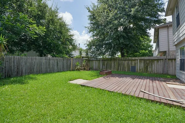 a view of wooden deck with a big yard