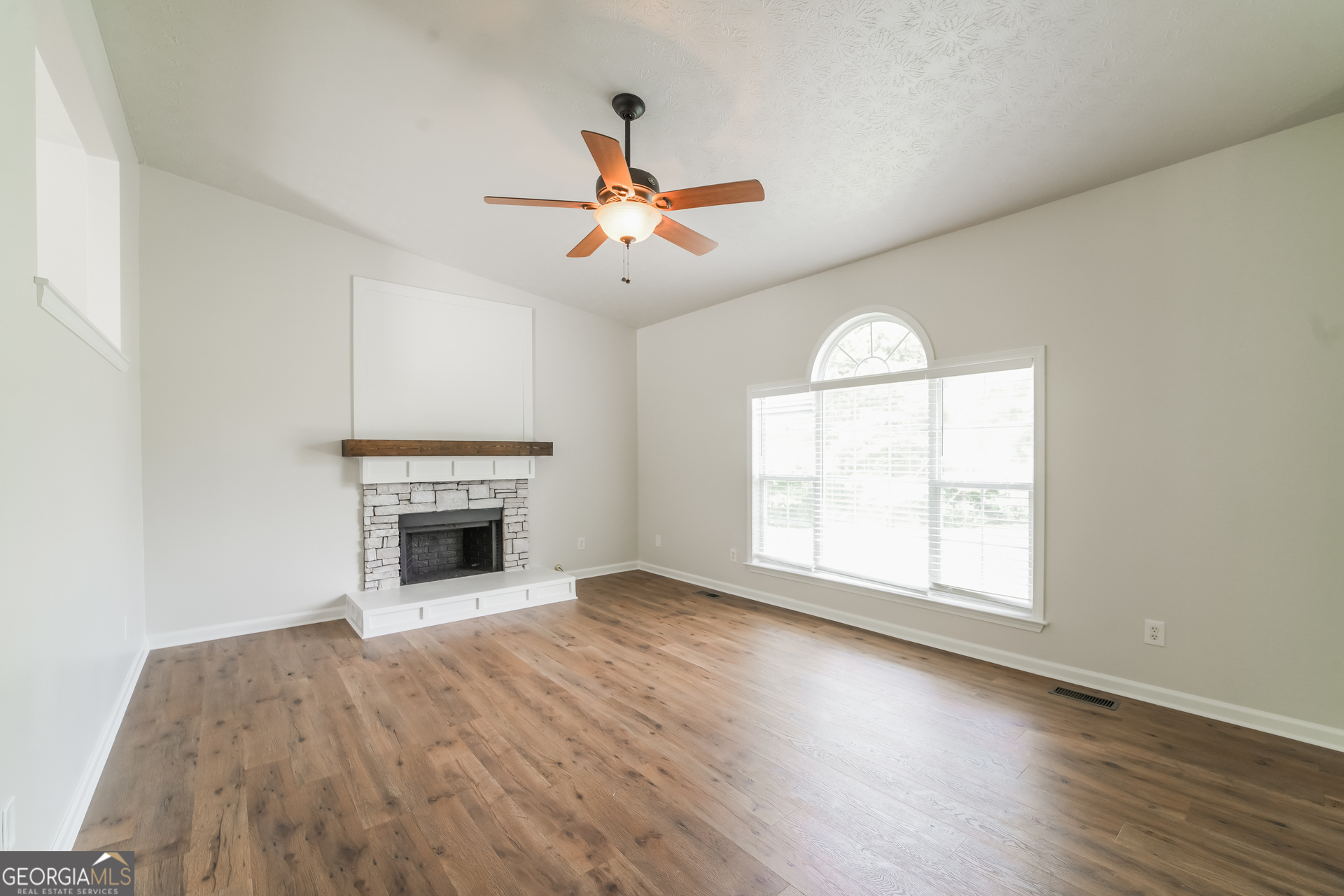 322 Yale Court Villa Rica, GA 30180 - Photo 3 of 17 an empty room with windows fireplace and a ceiling fan