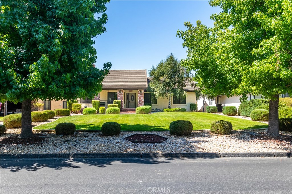 a front view of a house with garden and trees