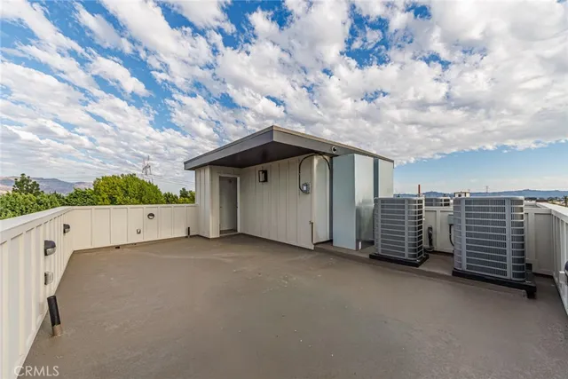 a view of a house with barbeque and wooden fence