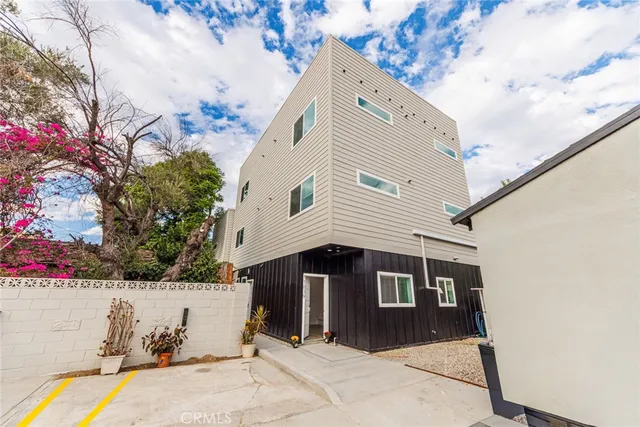 a front view of a house with a tree
