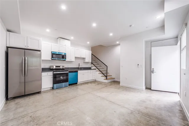 a kitchen with stainless steel appliances a refrigerator and a stove top oven