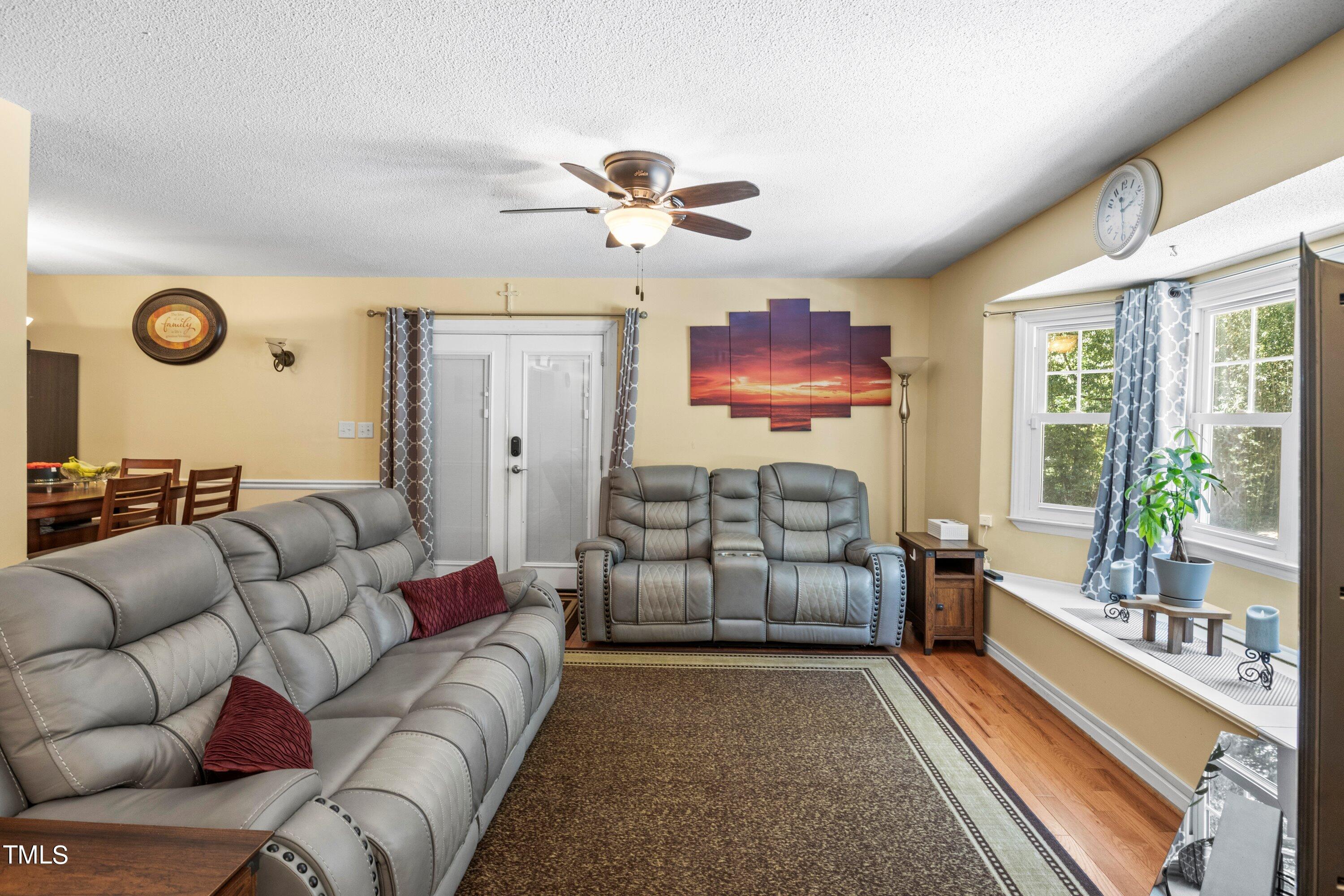 4125 Windsor Place Raleigh, NC 27609 - Photo 16 of 37 a living room with furniture a ceiling fan and a rug