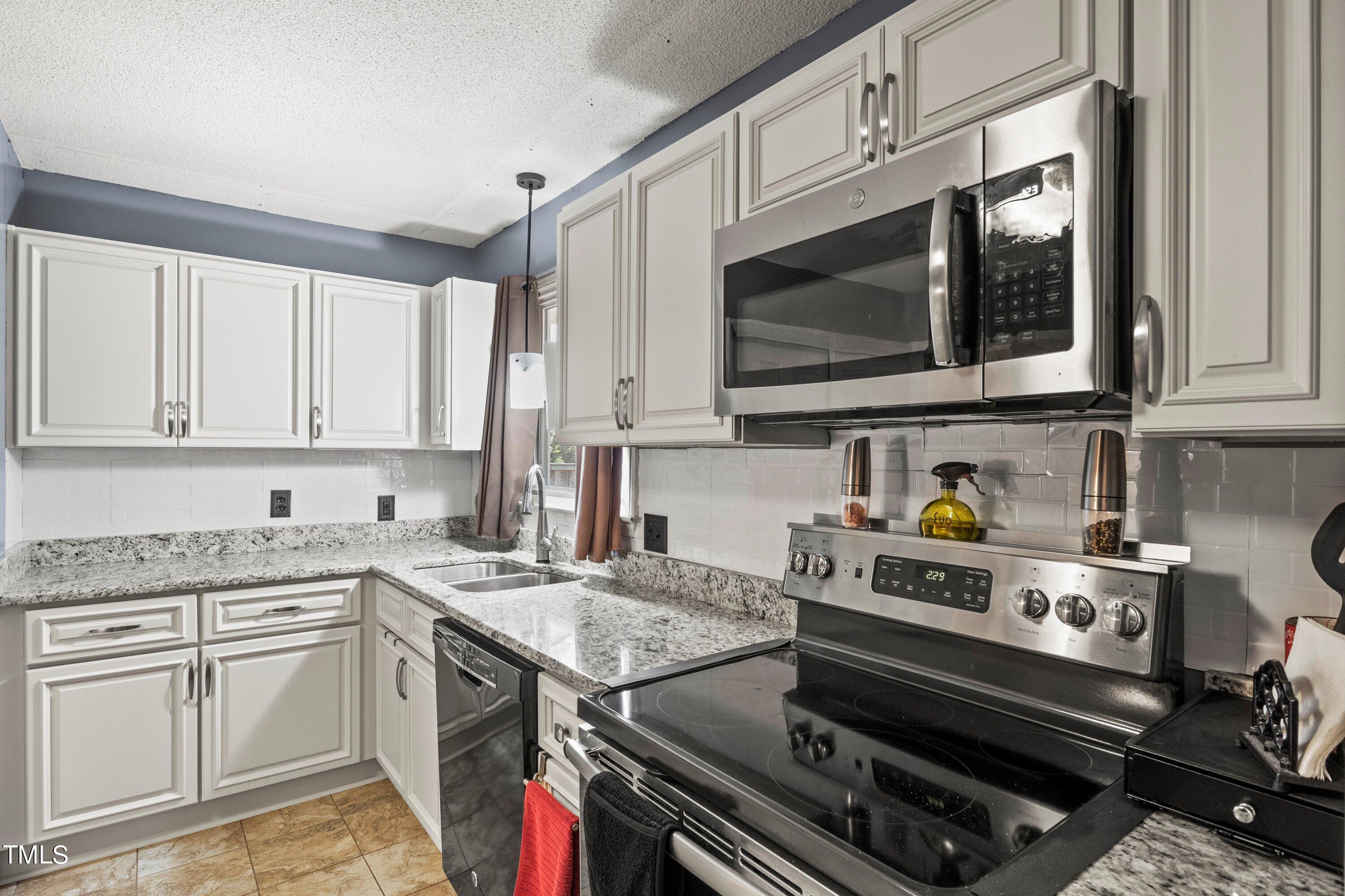 4125 Windsor Place Raleigh, NC 27609 - Photo 19 of 37 a kitchen with a stove and a microwave
