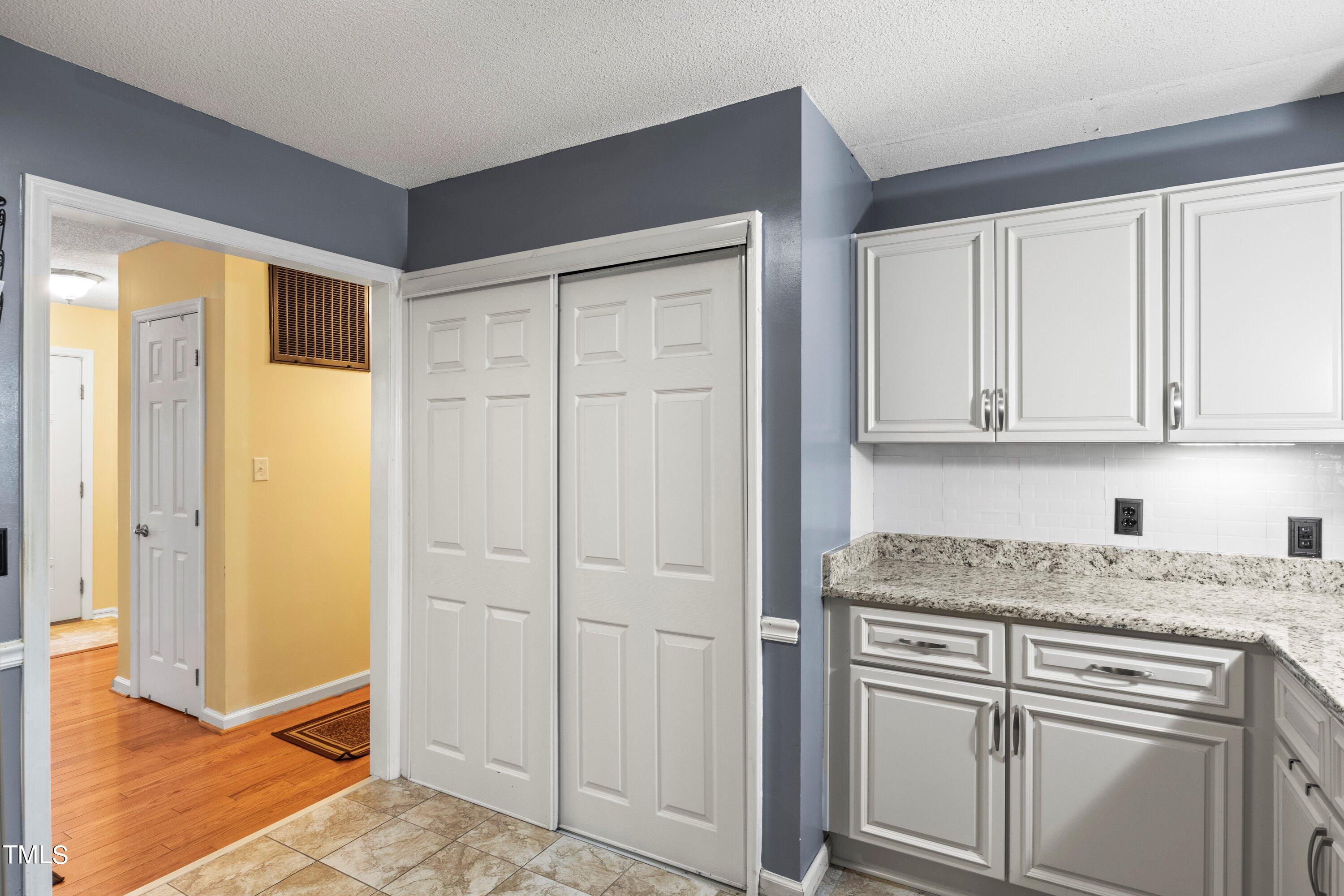4125 Windsor Place Raleigh, NC 27609 - Photo 21 of 37 a kitchen with white cabinets and white appliances