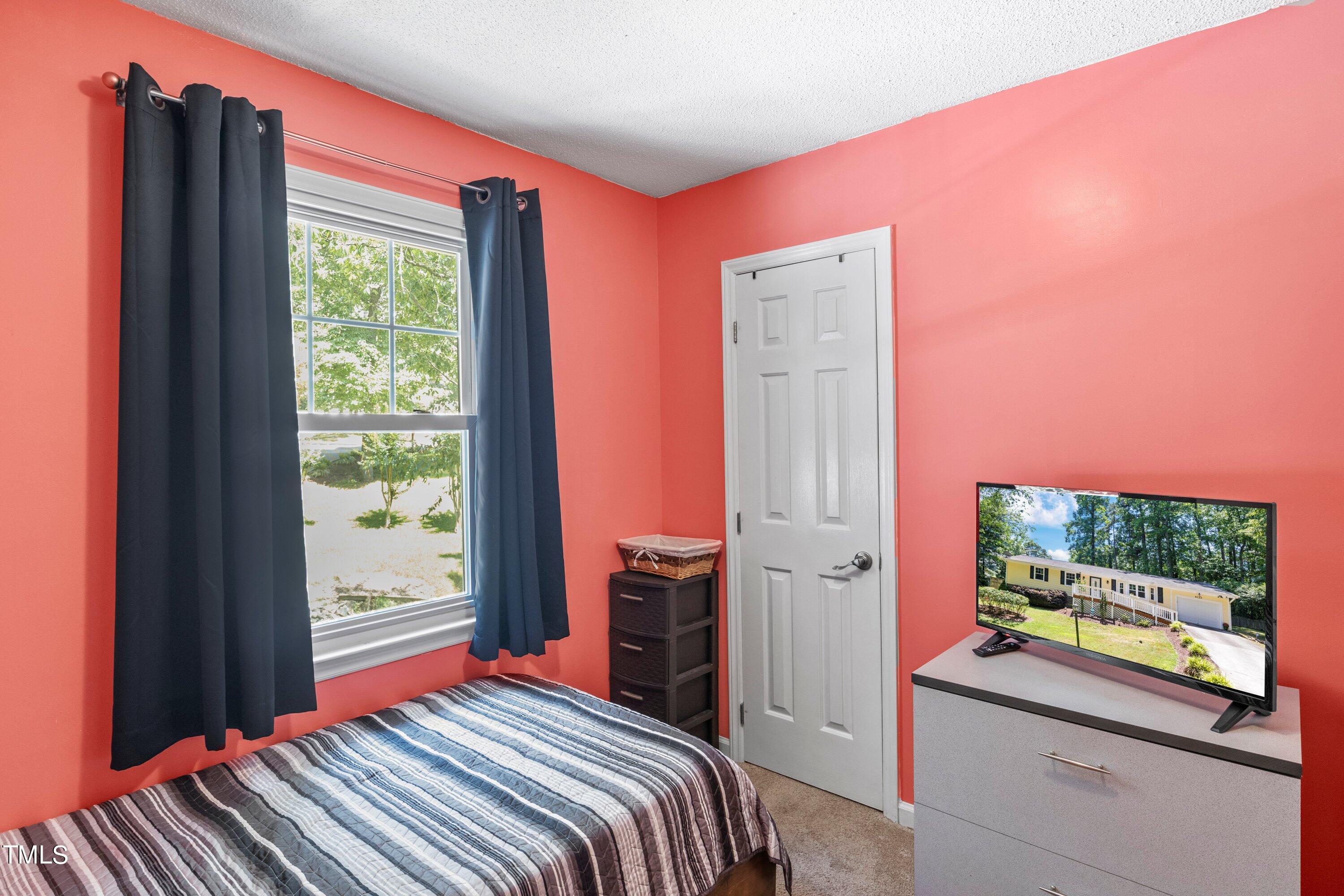 4125 Windsor Place Raleigh, NC 27609 - Photo 25 of 37 a bedroom with a bed and a flat screen tv