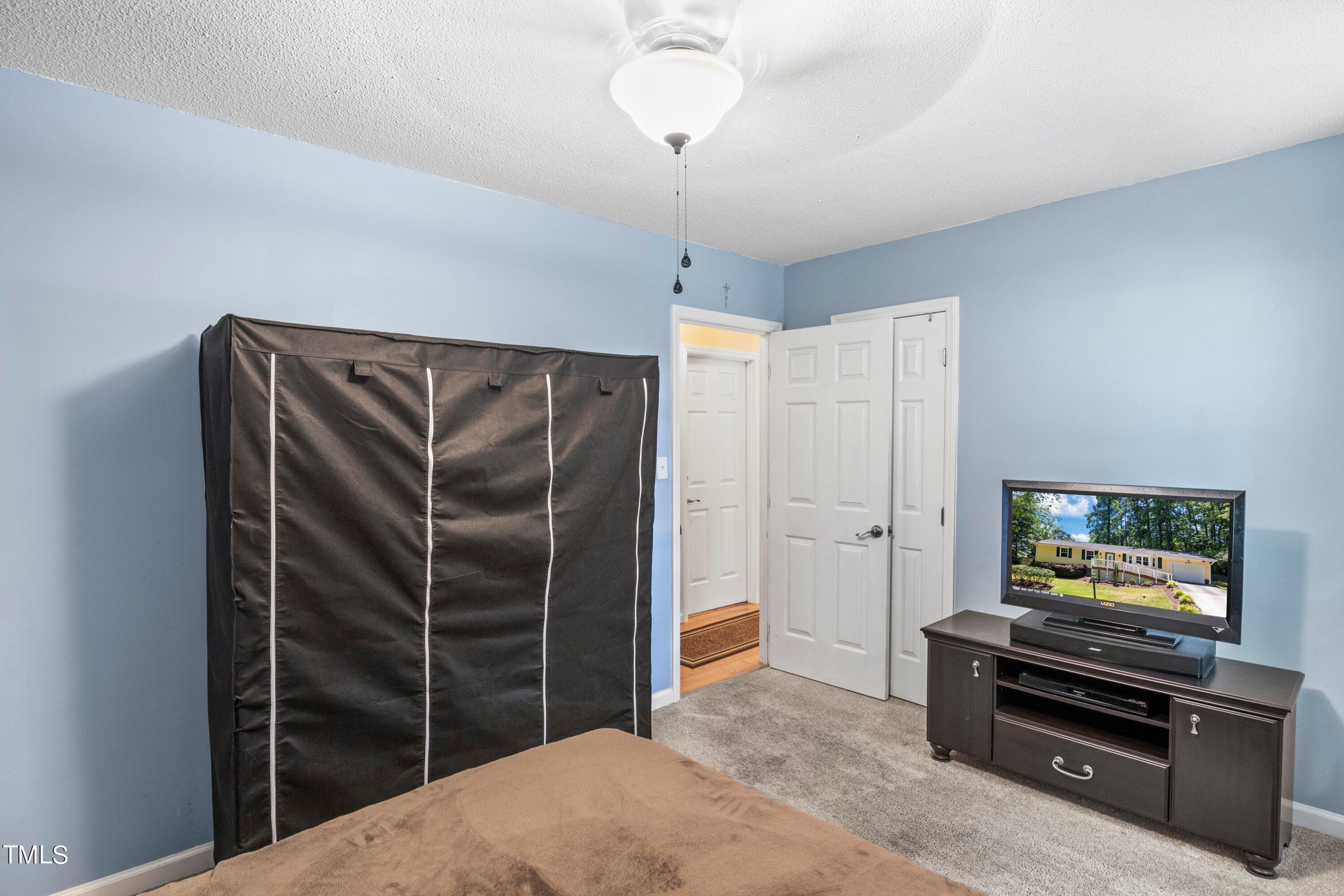4125 Windsor Place Raleigh, NC 27609 - Photo 27 of 37 a living room with closet and a flat screen tv