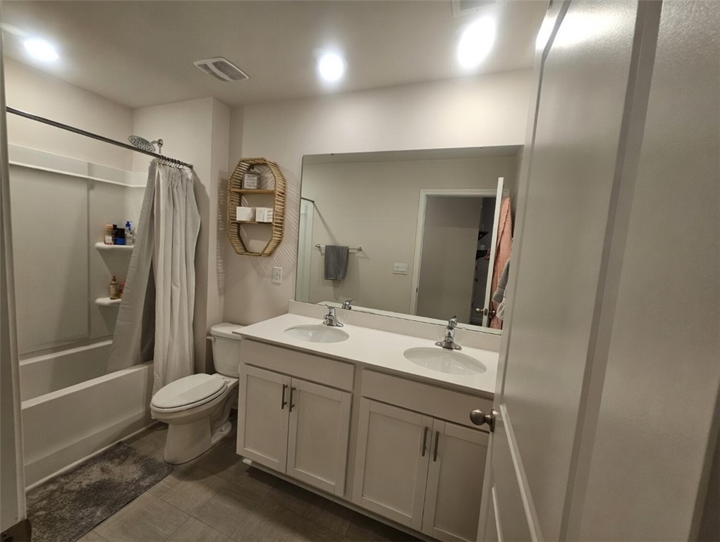 902 Ashwood Lane Easley, SC 29640 - Photo 26 of 39 A well-lit lavatory features a combined shower and tub, with a dual-sink vanity.