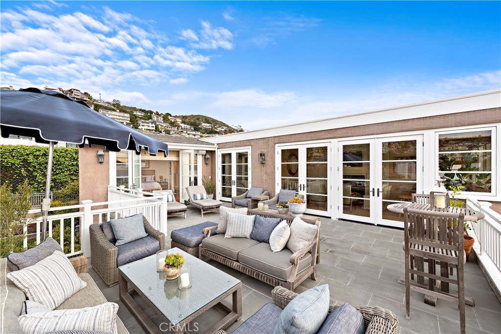 324 Emerald Bay Laguna Beach, CA 92651 - Photo 18 of 47 a view of a patio with couches chairs potted plants and floor to ceiling window
