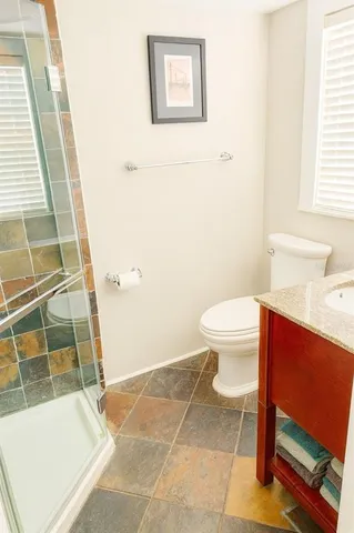 a bathroom with a toilet and a shower