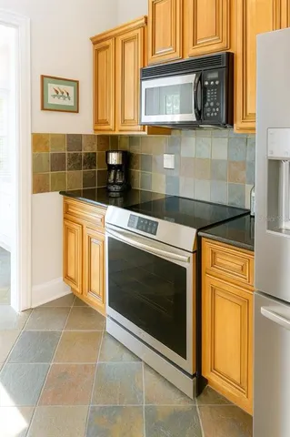 a kitchen with stainless steel appliances granite countertop a stove a microwave and a sink